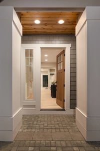 Entry way with a window next to the door and white trim.