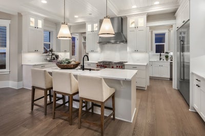 Kitchen with white cabinets and white stone countertops.