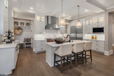 Kitchen with white cabinets and white stone countertops.