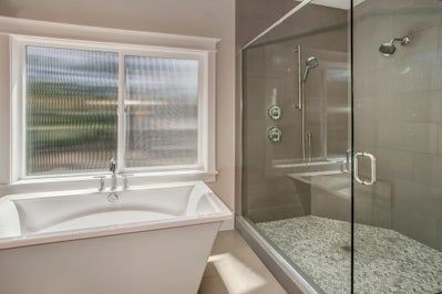 Soaking tub sits next to large walk in shower.