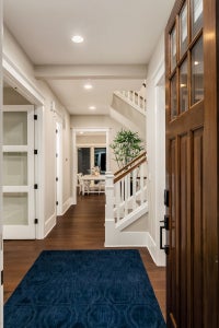 Entryway with staircase and hallway that leads to living spaces.