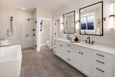 Large double sink white vanity with two mirror above each sink and black matte finishes.