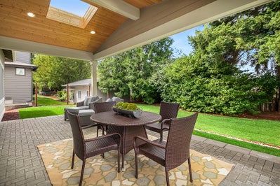 Outdoor dinning space overlooks landscaped yard.