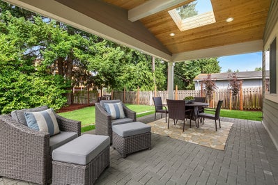 Patio with sitting spaced and outdoor dinning space sit below a vaulted cover.