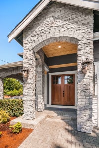 Entry way surrounded by stone with wooden double doors.