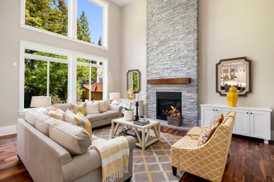 Great room with stone surrounded fireplace and wood mantle.