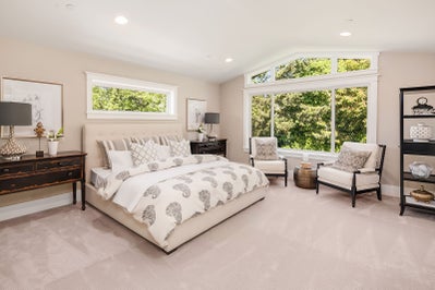 Master bedroom with large window above the bed, an even bigger window on the far wall and vaulted ceiling.