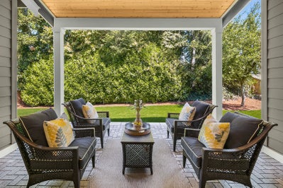 Covered patio space overlooking landscaped yard.