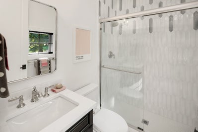 Tiled walk in shower with glass slider.
