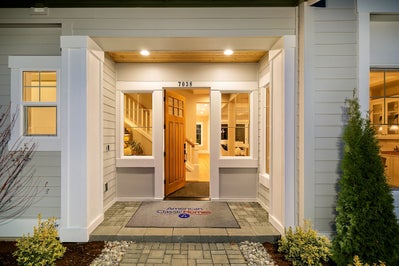 Entry way with windows on each side of the front door.