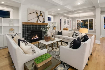 Great room with a fireplace at the center surrounded by black tile.