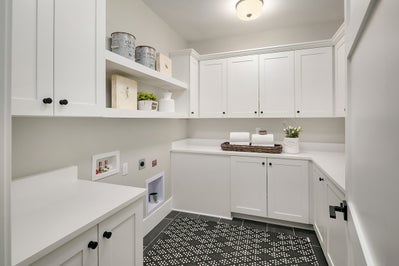 Laundry room with folding counter and white cabinets.