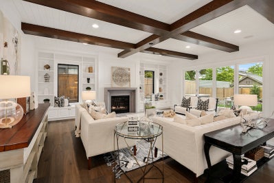 Great room with large sliding glass door and dark stained ceiling beams.