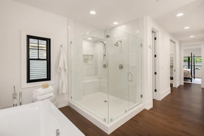 Large walk in shower incased in glass.