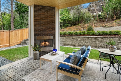 Covered patio with fireplace built into a brick wall.