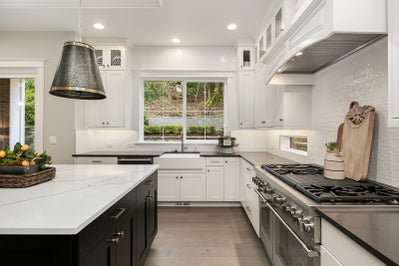 Kitchen with white cabinets and a window above sink