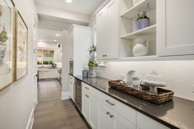 Buttler's pantry with white cabinets and black countertops