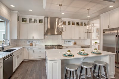 Kitchen with white cabinets and white stone countertops and a large island