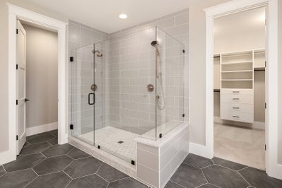 Large walk in tiled shower with dual shower heads, access to master closet from the master bathroom.