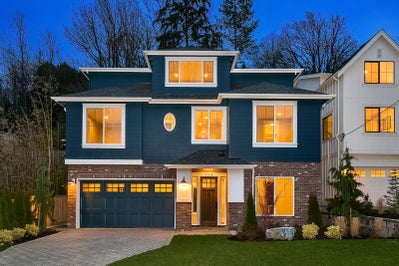 Exterior of a three story navy blue house with stone accents