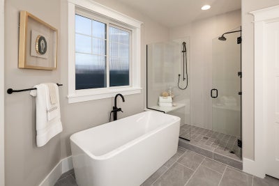 Soaking tub sits nect to large walk in shower with duel shower heads.