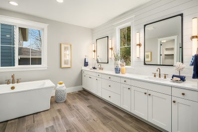 Large master bathroom with white vanity and soaking tub.