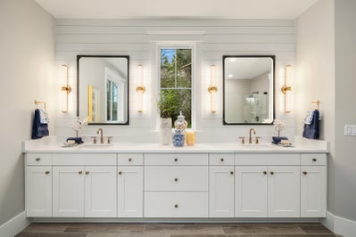 Large white vanity with duel sinks and four pillar lights.