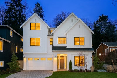 Three story white home with a two car garage