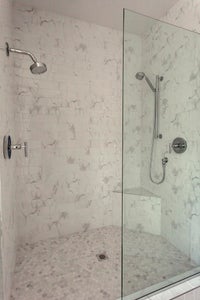 Walk in stoine shower with double shower heads.