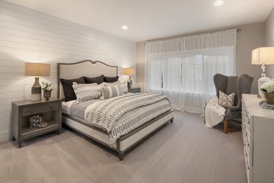 Master bedroom with a shiplapped wall.