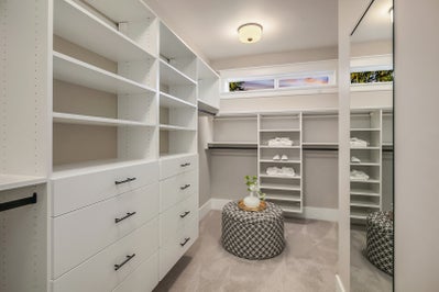 Master closet with large mirror and built in wood shelving.