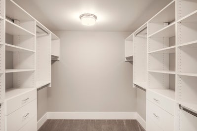 Master closet with wood built in shelving.