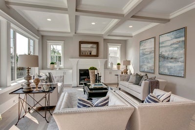 Great room with white fireplace and ceiling beams.