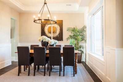 Formal dinning space with wainscoting and custom lighting.